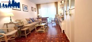 a living room with a couch and tables and chairs at Apartamento las Huertas in Santoña