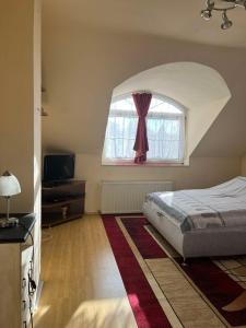 ブダペストにあるD&D Apartmanのベッドと窓のある寝室