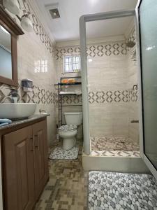 a bathroom with a toilet and a sink and a shower at Celebrity Suite - 3 Bedroom in Beterverwagting