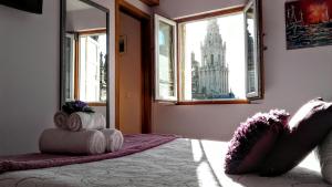 a bedroom with a bed with a view of a building at Apartamentos Casa de La Inmaculada in Santiago de Compostela