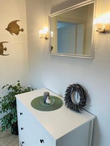 a plate on a dresser with a cup and a mirror at OstseeLiebe Garten, Terrasse und Strandnähe in Wendtorf +24 photos