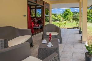 a living room with chairs and tables and a patio at Kovailani 1232 DTO-MT in Bora Bora