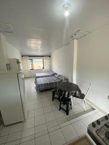 a bedroom with a bed and a table in it at Pousada Vista da Lagoa in Florianópolis