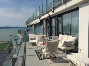 a balcony with chairs and a table on a building at Lelle Marine Resort Voila Apartman in Balatonlelle