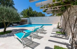 a group of chairs and a swimming pool at Villa F in Vrgorac - Makarska in Vrgorac