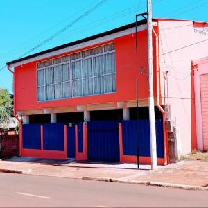 een rood en blauw gebouw aan de straatkant bij Apart Morel in Puerto Iguazú