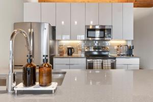 ジャージー・シティーにあるThe Aurelia - Luxury Industrial Loft near NYCのキッチン(ステンレス製の電化製品、カウンタートップ付)