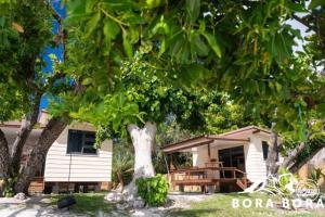 a house with a tree in front of it at Matira Beach Raitea 2 in Bora Bora