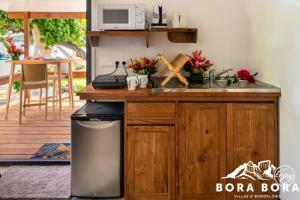 a kitchen with a sink and a counter with a microwave at Matira Beach Raitea 2 in Bora Bora