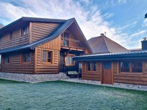 a wooden house with a porch and a balcony at Drevenica Skye Terchová in Terchová +37 photos