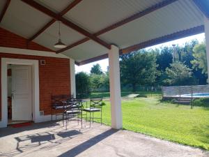 eine Terrasse mit Stühlen und einem Tisch und einem Gebäude in der Unterkunft Shakty "Apart de Montaña" in Los Reartes