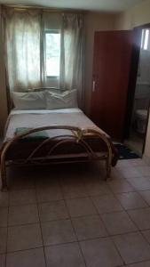 a bed sitting in a room with a window at Princess self catering apartments in Kololi +13 photos
