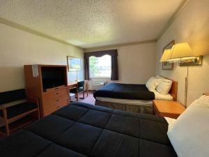 Postel nebo postele na pokoji v ubytování Tamarack Inn
