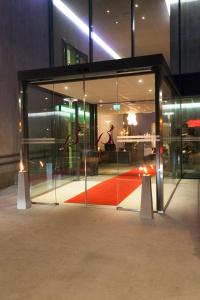 a glass entrance to a building with a red carpet at Bryne Hotell in Bryne