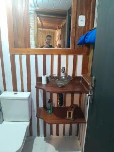 Chalé Bambu في كونها: حمام مع حوض ورجل في المرآة