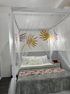 a bed with a canopy in a bedroom at Dajon-6 Family Suite in General Luna