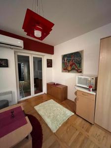 Una sala de estar con microondas y una mesa. en Dalijan Apartman, en Ohrid