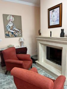 a living room with two chairs and a fireplace at Casa Roma in Casinos