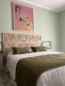 a bedroom with a large bed with a painting on the wall at Casa Roma in Casinos
