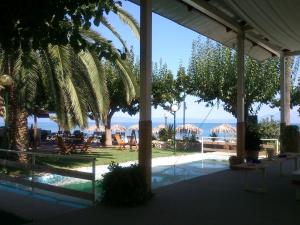 a view of a resort with a pool and palm trees at Evoikos beach & resort in Livanates