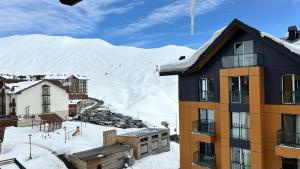 un edificio di fronte a una montagna innevata di Two-storey apartment BlockF1 a Kʼumlistsʼikhe