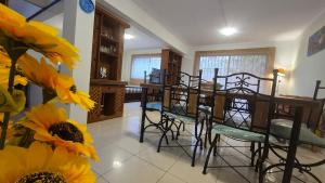 una sala da pranzo con tavolo, sedie e fiori di Departamento Centro La Serena a La Serena