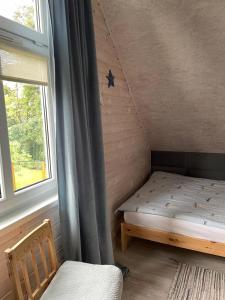 a small bed in a room with a window at pod lipą in Ustka