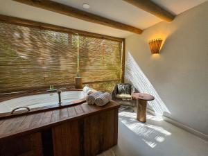 a bath tub in a room with a window at Amaia Trancoso Hotel in Trancoso +85 photos