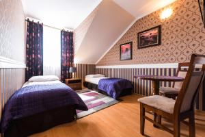 a bedroom with two beds and a table and a chair at Noclegi Komfort in Lublin