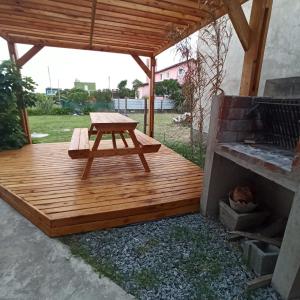 a wooden deck with a picnic table and a grill at Casa vacacional LUNA DE MAR in Santa Clara del Mar