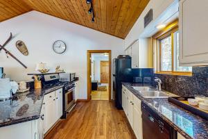 a kitchen with white cabinets and a black refrigerator at Ollie's Place in Breckenridge