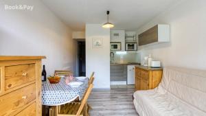 Una sala de estar con una mesa y una cocina. en Studio soyouz, en Villarembert