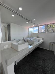 a bathroom with three sinks and two mirrors at Puebla Inn Express in Puebla +85 photos