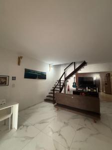 a living room with a fireplace and a staircase at Paradise Suítes in Arraial do Cabo