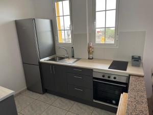 eine Küche mit einem Kühlschrank aus Edelstahl und einer Spüle in der Unterkunft Villa Kary in Arona + 11 Fotos