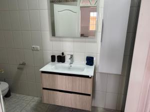 ein Badezimmer mit Waschbecken und Spiegel in der Unterkunft Villa Kary in Arona