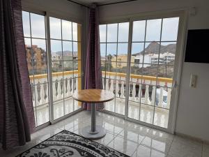 Zimmer mit einem Tisch vor einem großen Fenster in der Unterkunft Villa Kary in Arona