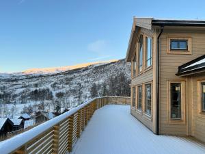a balcony of a house with snow on the ground at Høgerinden Lodge in Sogndal