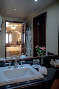 a bathroom with a sink and a large mirror at Villa Maria Cristina Hotel in Guanajuato