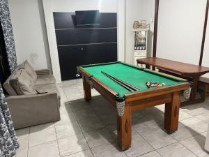 a living room with a pool table and a couch at Casa do Bert Pousada in Itanhaém