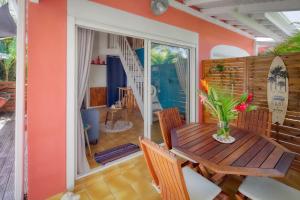 a dining room with a wooden table and chairs at Villa Petite Terre à 50 mètres de la plage in Saint-François