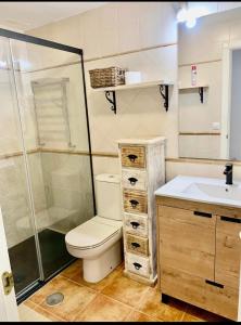 a bathroom with a toilet and a shower and a sink at Canela Garden in Isla Canela