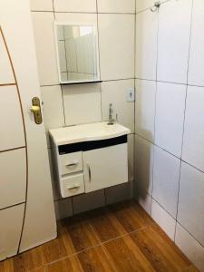 une salle de bain avec un lavabo et un miroir dans l'établissement Cantinho Oliveiras, à Cabo Frio