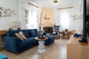 a living room with a blue couch and a table at Cookoo Villas in Kriopigi