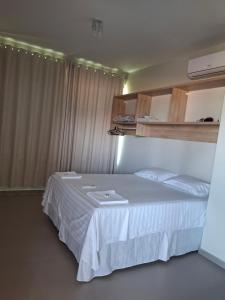 a bedroom with a white bed in a room at Casa da praia in Tutóia +5 photos