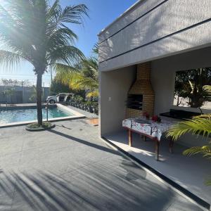 Un patio con una mesa junto a una piscina. en Villa Rocha mar, en São José de Ribamar