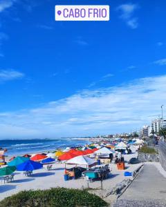 - une plage avec des parasols colorés et l'océan dans l'établissement Cantinho Oliveiras, à Cabo Frio