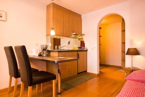 a kitchen with a table and chairs in a room at MOM - Alpine Boutique Apartments, Chalet Fagus, Terrace Studio in Grindelwald