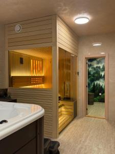 a bathroom with a tub and a sink at Brvnara Mont 2 in Zlatibor