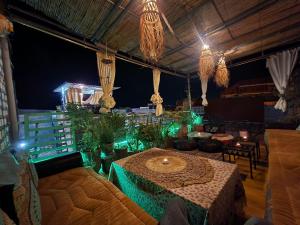 a room with a table and some plants and lights at Quadra Sphere rooftop in Tamraght Ouzdar